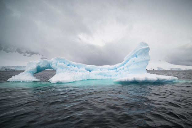 Iceberg en el mar bajo un cielo nublado en la Antártida