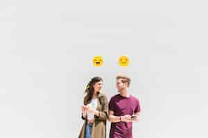 Foto gratuita icono sonriente sobre sonriente pareja joven con smartphone