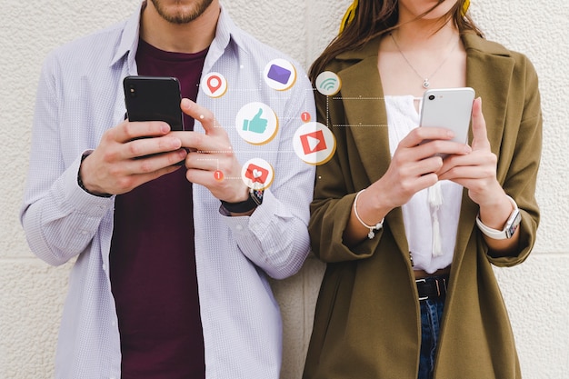 Foto gratuita iconos de notificación móvil entre hombre y mujer usando teléfono celular