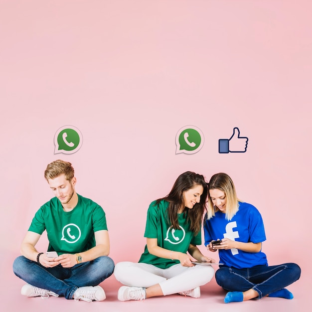 Iconos de redes sociales sobre grupo de amigos que usan teléfono móvil