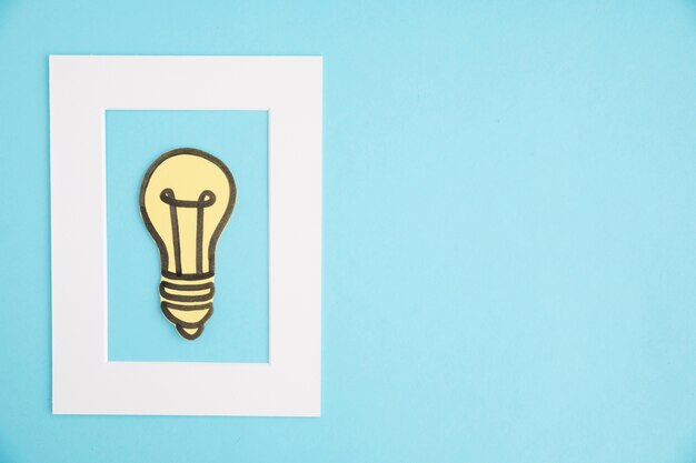 Idea bombilla marco blanco sobre fondo azul