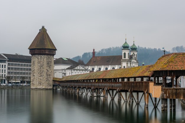 Iglesia de los jesuitas de Lucerna rodeada de agua bajo un cielo nublado en Lucerna en Suiza