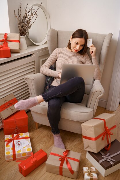 Imagen de agradable mujer feliz con tarjeta de crédito con espacio de copia usando laptop