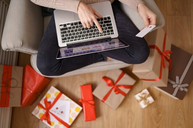 Imagen de agradable mujer feliz con tarjeta de crédito con espacio de copia usando laptop