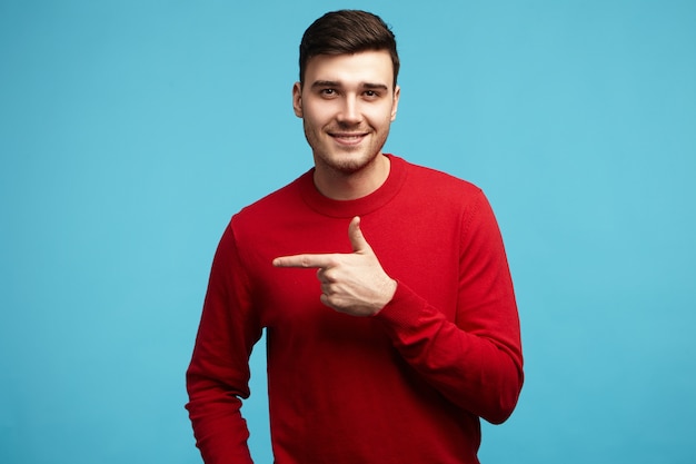 Imagen aislada de hombre joven de moda positivo con peinado elegante y cerdas sonriendo a la cámara