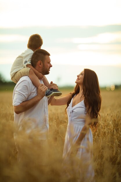 Imagen de alegre mamá caucásica, papá y su hijo se divierten juntos y sonrisas en el campo