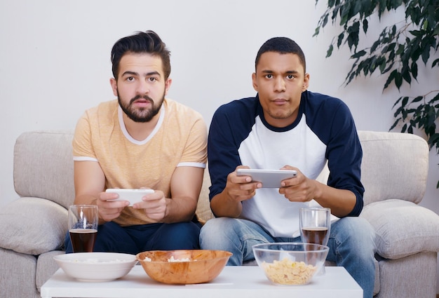 Imagen de amigos felices jugando juegos de computadora. Hombres guapos mirando la pantalla de televisión y listos para la batalla entre ellos.