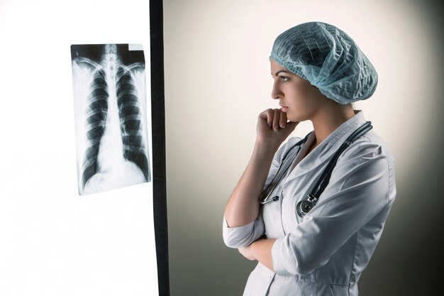 Imagen de atractiva doctora mirando resultados de rayos x