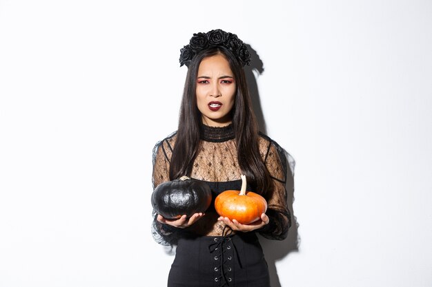 Imagen de bruja enojada haciendo muecas arrojando calabazas