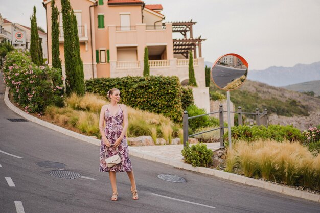 Imagen completa de una mujer elegante caminando en Montenegro y disfrutando de sus vacaciones de verano