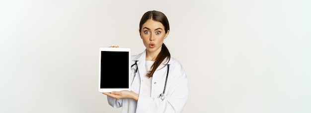 Imagen de una doctora trabajadora de atención médica que muestra la pantalla de una tableta digital de un sitio web médico en línea