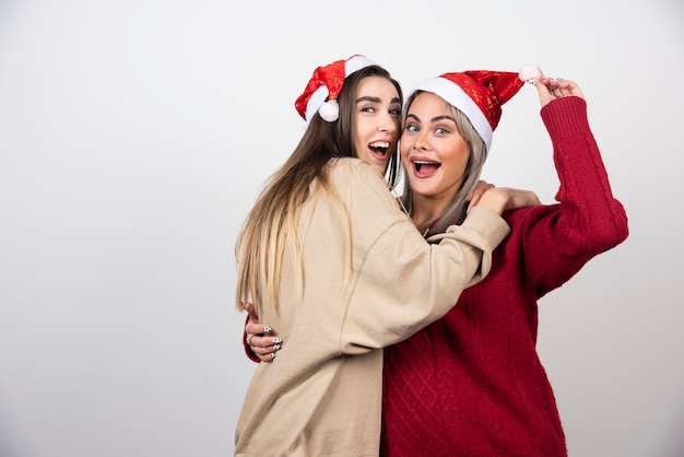 Foto gratuita imagen de dos amigas sonrientes de pie y abrazándose.