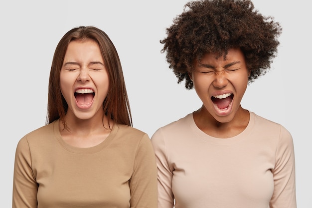 Imagen de dos mujeres estresadas gritar en voz alta