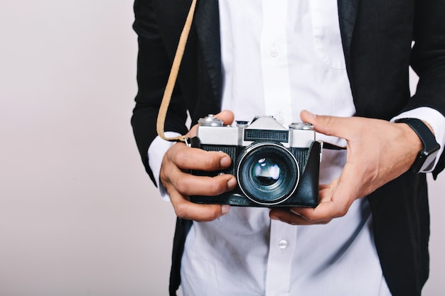 Imagen elegante de cámara retro en manos de chico guapo en traje. Ocio, periodista, fotografía, aficiones, diversión.