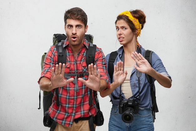 Foto gratuita imagen de elegantes jóvenes europeos turistas y viajeros europeos, viajeros o aventuras que parecen frustrados y preocupados, mostrando un gesto de parada con las manos, tratando de resolver el conflicto mientras viajan