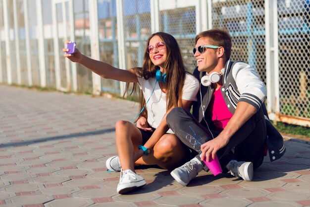 Imagen de estilo de vida de verano de elegante hermosa pareja de enamorados haciendo autorretratos colores de verano.