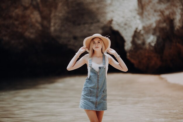 Imagen de estilo de vida de verano de feliz mujer impresionante caminando en la playa de la isla tropical. Sonriendo y disfrutando de la vida en el paraíso.