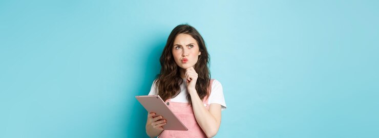 Foto gratuito imagen de una estudiante pensativa mirando la esquina superior izquierda y pensando sosteniendo una tableta digital