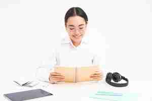 Foto gratuita imagen de una estudiante trabajadora asiática con anteojos estudiando sosteniendo un cuaderno trabajando en el proyecto iso