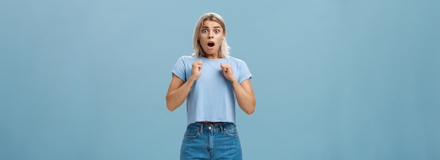 Imagen de estudio de una chica aturdida y conmocionada de pie en estupor con la mandíbula caída y la mirada asustada