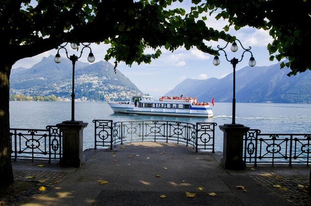 Imagen fascinante de un velero contra las montañas brumosas en Lugano, Suiza