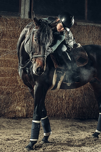 Imagen de feliz mujer sentada en caballo de raza pura