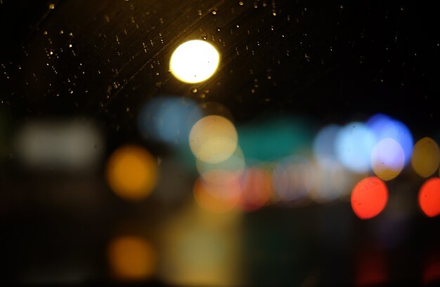 Imagen de gotas de lluvia en la ventana en la noche en la ciudad