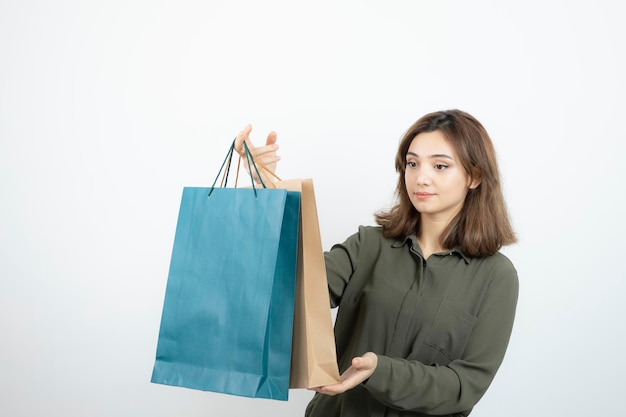 Imagen de una hermosa chica de pelo corto con bolsas de compras de pie. foto de alta calidad