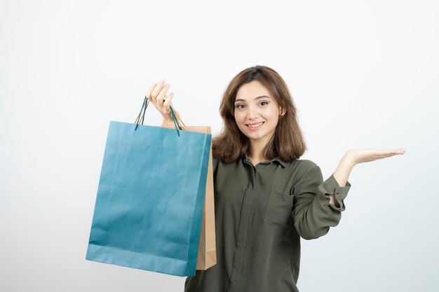 Imagen de una hermosa chica de pelo corto con bolsas de compras de pie. foto de alta calidad