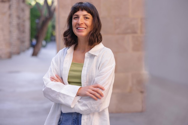 Imagen de una hermosa mujer sonriendo a la cámara en la ciudad