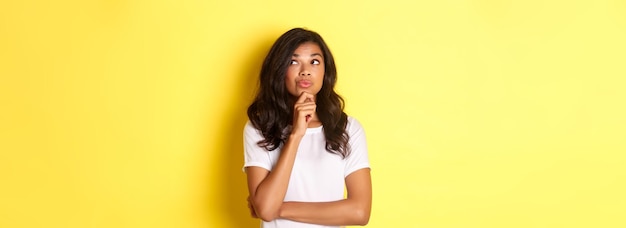 Foto gratuita imagen de una hermosa niña afroamericana pensativa haciendo su elección mirando en la esquina superior derecha