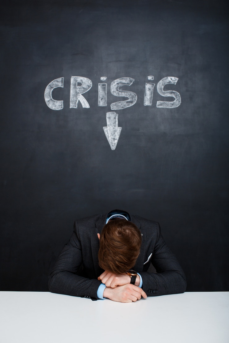 Foto gratuito imagen de un hombre cansado sobre una pizarra con la inscripción de crisis
