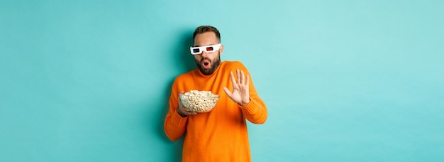 Foto gratuita imagen de un hombre con gafas d viendo una película asustada de los efectos especiales mirando con asombro de pie w