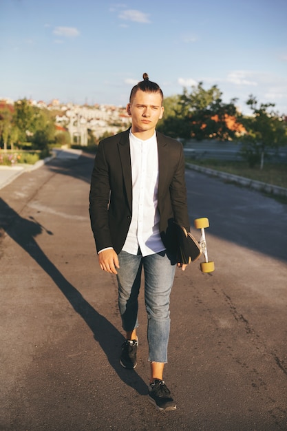 Imagen de un hombre con longboard en camino