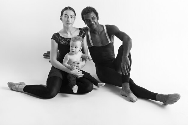 La imagen incolora de la feliz familia de bailarines de ballet en blanco studio