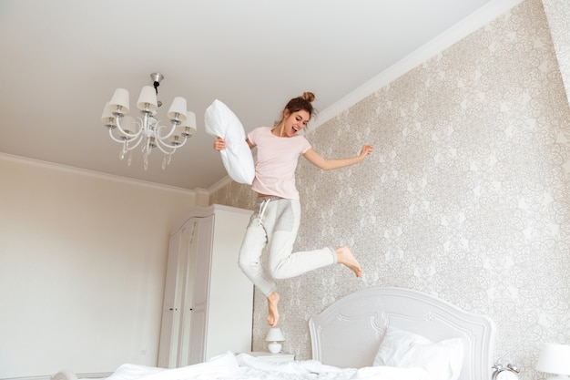 Foto gratuita imagen integral de joven divirtiéndose en la cama