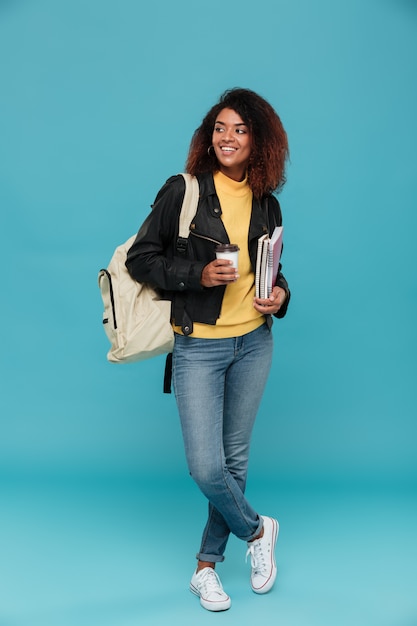 Imagen integral de sonriente mujer africana en chaqueta de cuero