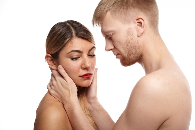 Foto gratuita imagen íntima de una pareja adulta de hombres y mujeres sin ropa. tiernos socios caucásicos haciendo el amor: hombre barbudo tocando la cara bonita de la mujer rubia tímida que está mirando hacia abajo