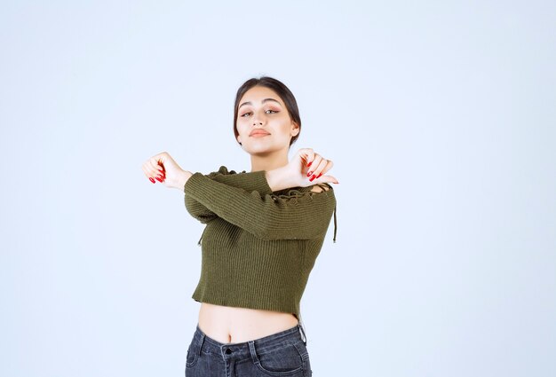 Imagen de una joven y bella mujer modelo de pie y posando con los brazos cruzados.