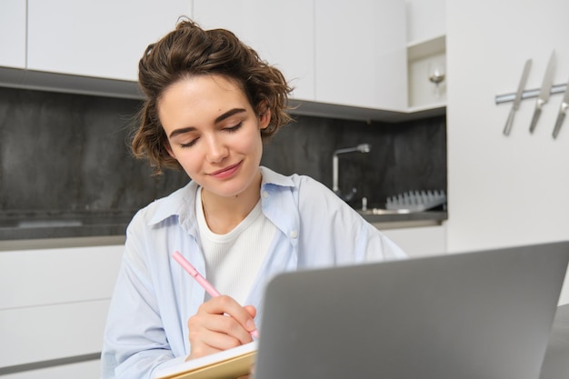 Foto gratuita imagen de una joven empresaria trabaja desde casa una niña estudia de forma remota anota información hace