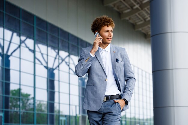 Imagen del joven empresario pelirrojo hablando por teléfono mirando a un lado