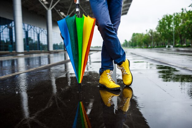 Imagen del joven empresario 39 s zapatos amarillos y paraguas multicolor en calle lluviosa