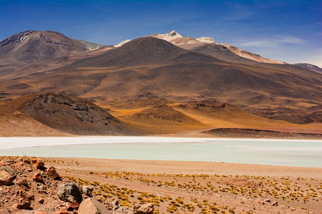 Imagen de un lago contra fascinantes montañas marrones bajo el gran cielo