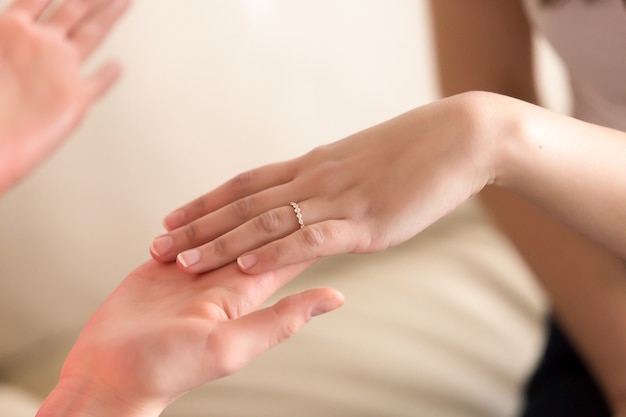 Imagen de mano femenina con anillo en el cuarto dedo.