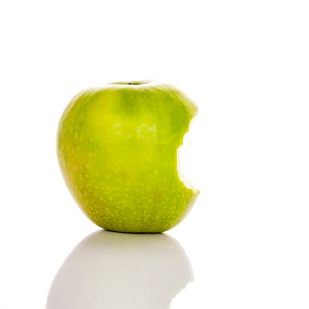 Imagen de manzana verde mordida sobre un fondo blanco.