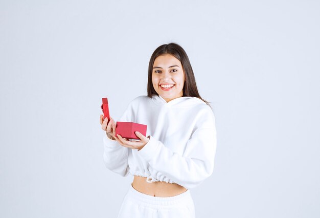 Imagen de una modelo bastante joven sosteniendo una caja de regalo. H