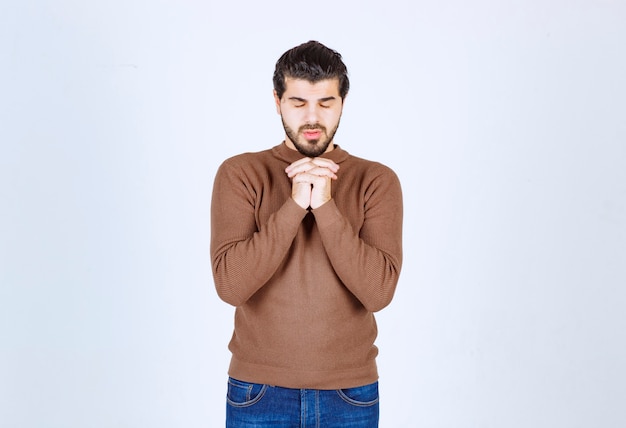 Imagen de un modelo de hombre guapo tomados de la mano junto con los ojos cerrados