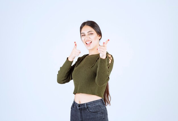 Imagen de un modelo de mujer joven de pie y apuntando a un lado con el dedo índice