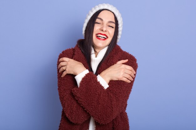 Foto gratuita imagen de mujer alegre magnética con cabello negro abrazándose a sí misma