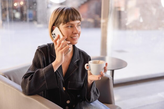 Imagen de mujer con café hablando por celular